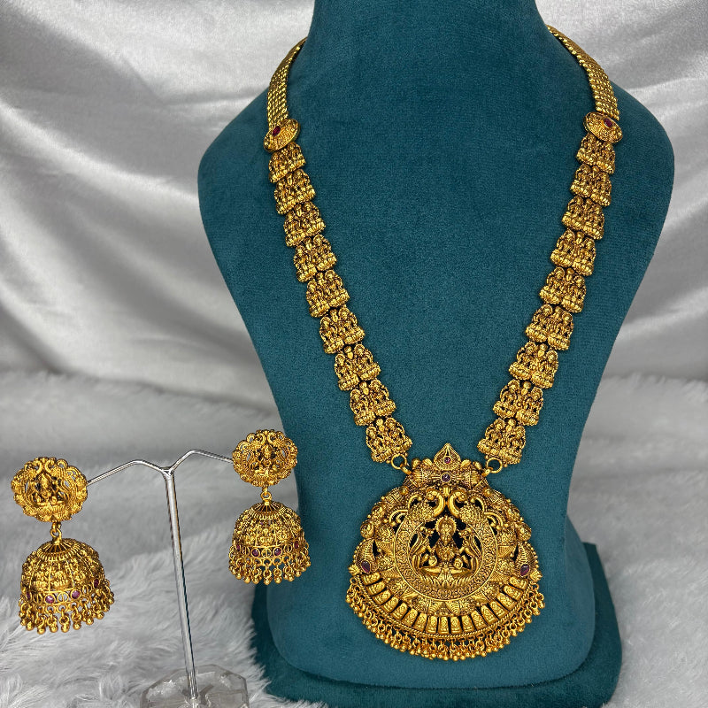 Gold necklace and earrings on a blue mannequin with a white fabric background