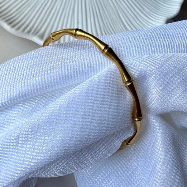 Gold bracelet on a white fabric background